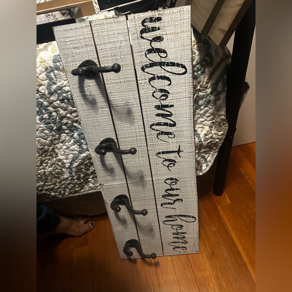 Wall hanging sign with coat hooks.
